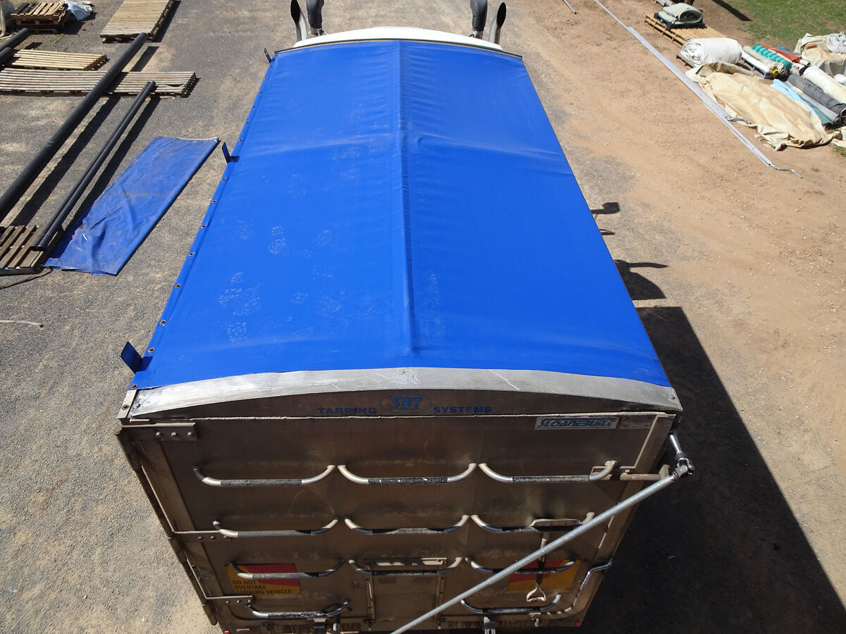 Top down view of a blue roll over tarp on a truck