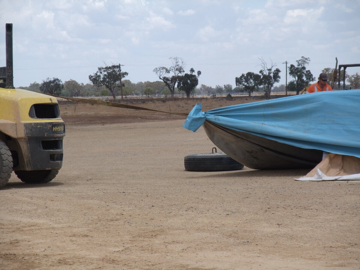 A forklift is used to help fit an Ellis and Sons Group grain bunker tarp cover