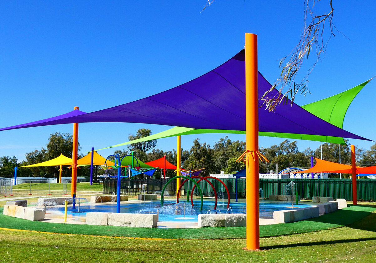 Pool covered by different coloured hypar shade sails.