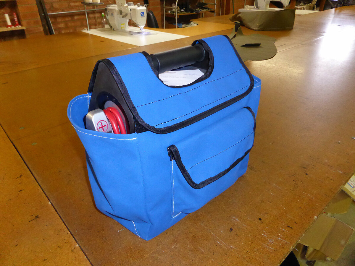 Blue tool bag on a large industrial sewing machine table