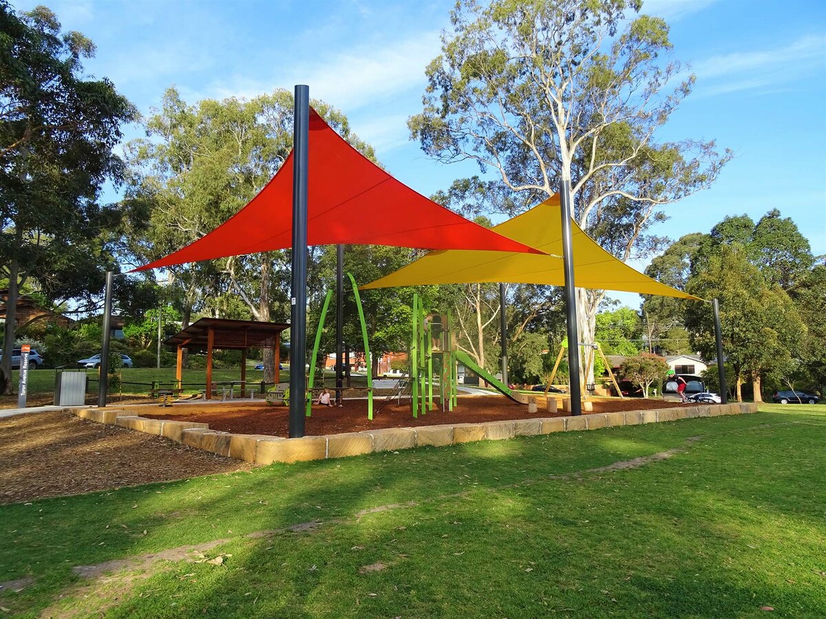 Red and yellow shade sails cover a playground