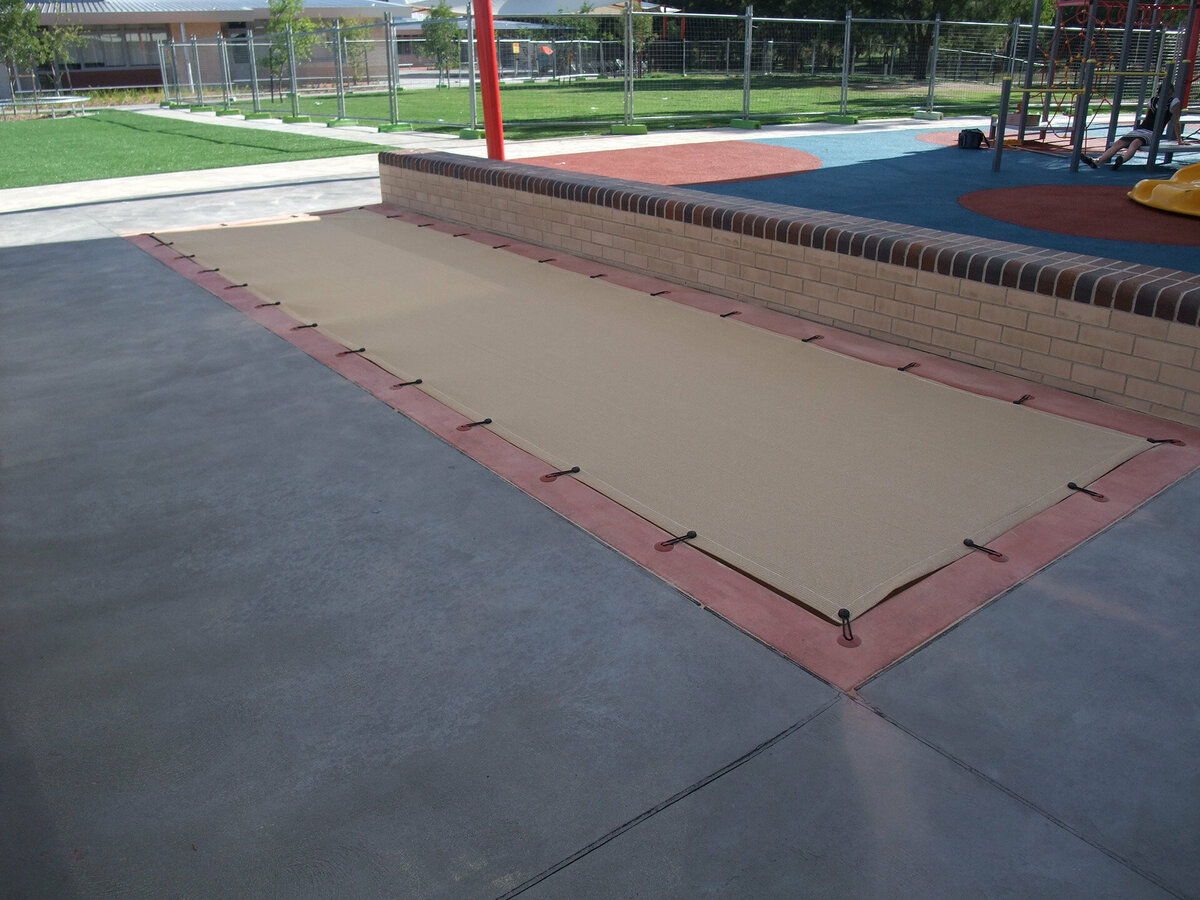 Sand pit at a playground covered with a mesh shade cloth