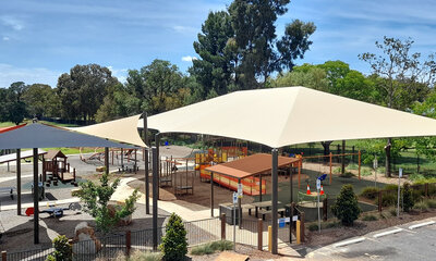 White hip structure shade sails covering a playground