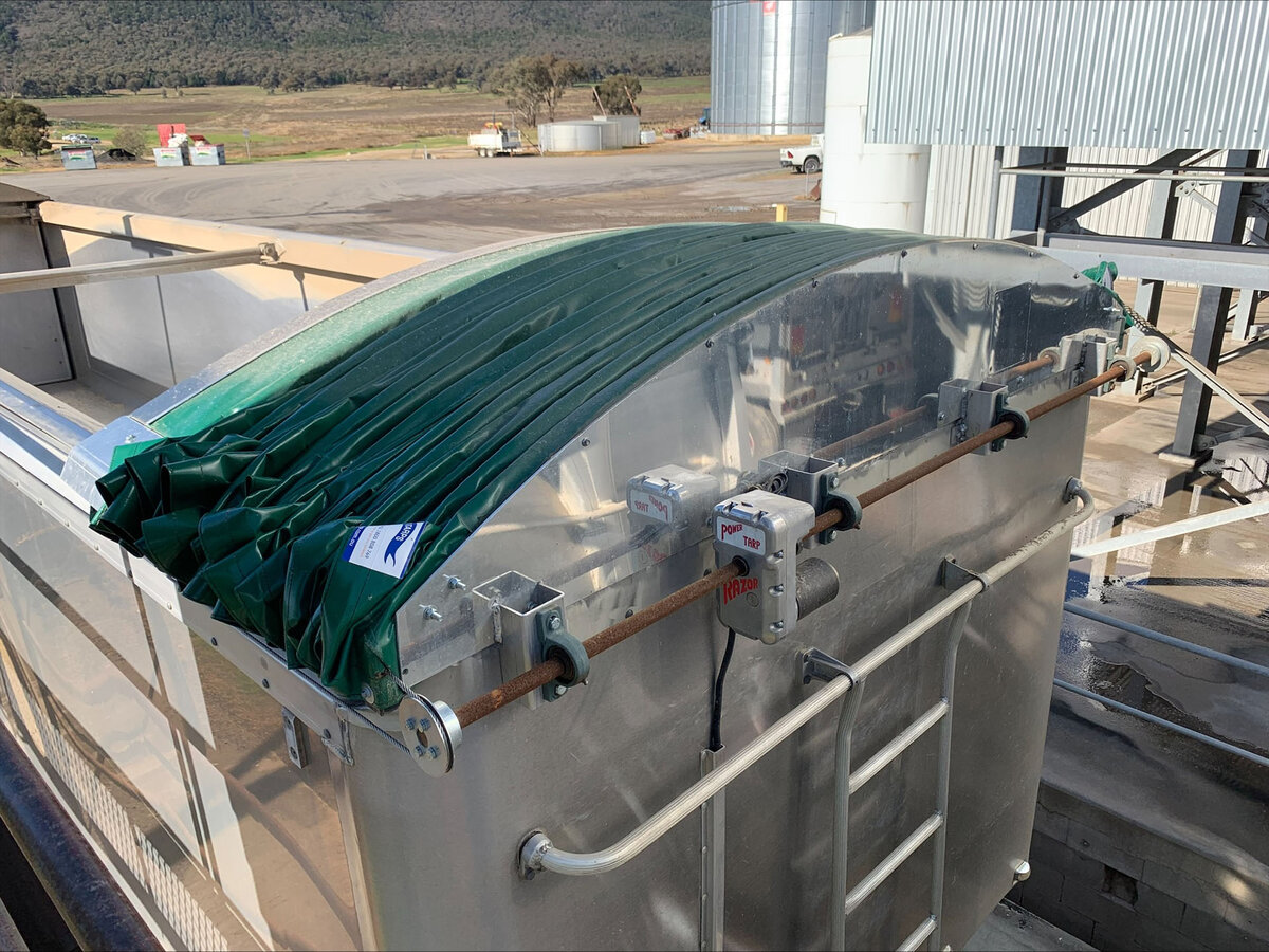 Close look at a green retractable tarp fitted to a grain trailer