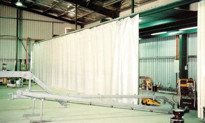 A truck curtain hanging up in a large warehouse