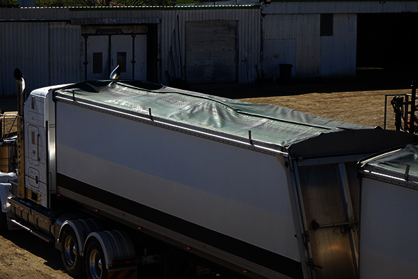 A semi-trailer loaded with too much cotton seed in the centre of the bin.