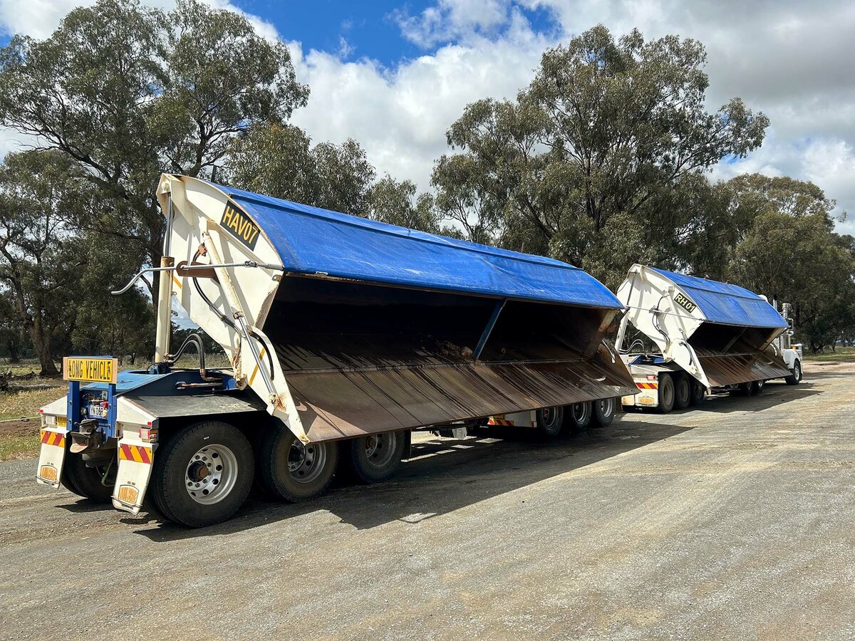 A truck roll over tarp covering 2 trailers tipped to the side